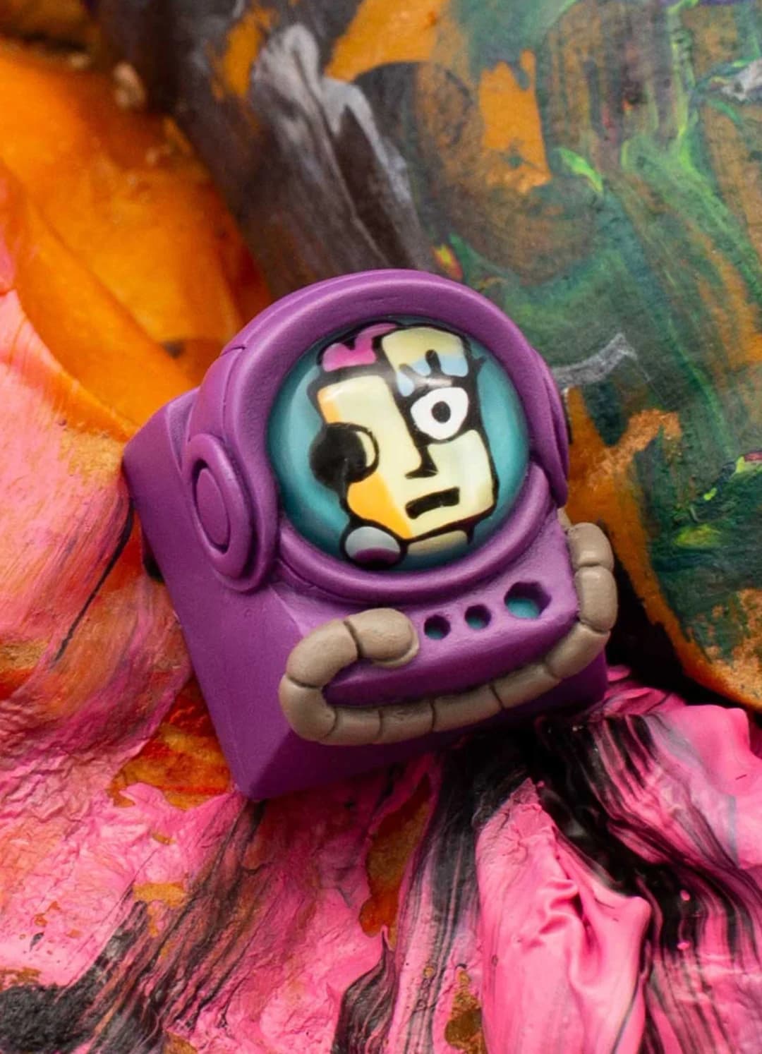 Suzie Monster Mash Cadet with an asymmetrical multicolour face in a purple helmet.