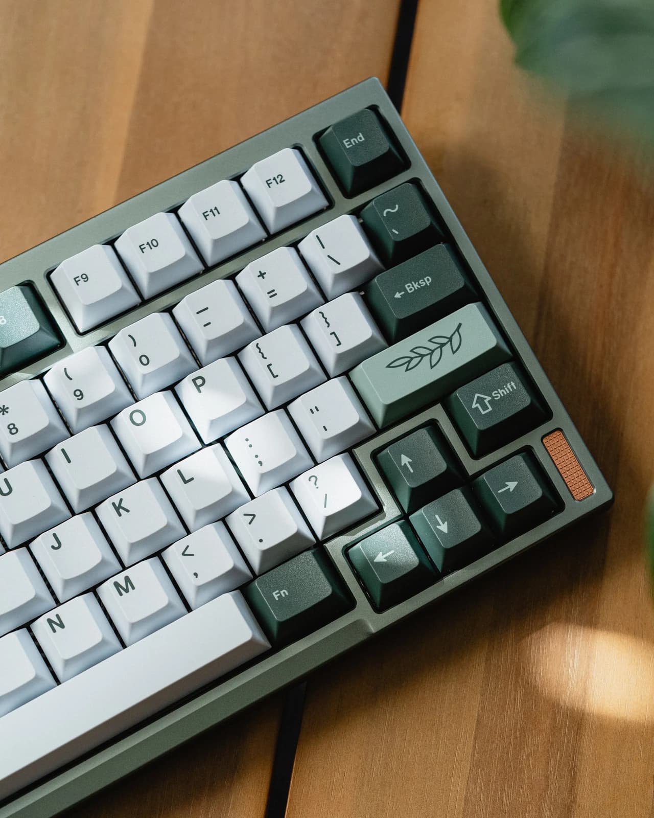 White and green Botanical keycaps with a leaf novelty, shown on a green keyboard.